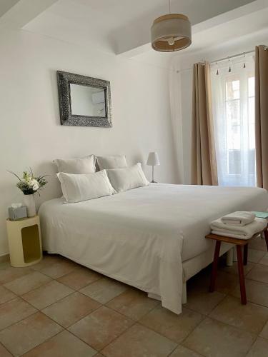 - une chambre blanche avec un grand lit blanc et un miroir dans l'établissement Appartement 2 BED SWAN HOUSE Cannes la croisette, à Cannes