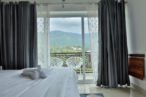 a bedroom with a bed and a large window at Banbury Bungalow in Kanthalloor
