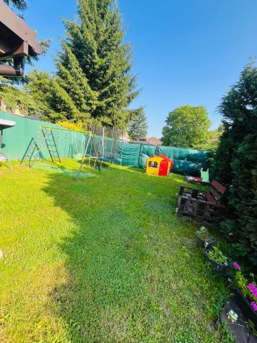 a yard with a fence and a swing set at Apartmán Zara in Dobrá Voda