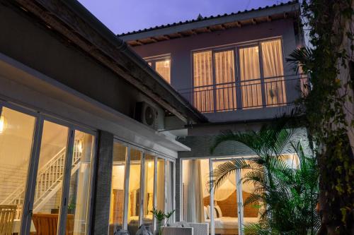an exterior view of a house with large windows at Private-Pool Family Villa near Canggu Beach in Tumbak Bayuh