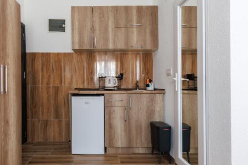 a kitchen with wooden cabinets and a white refrigerator at Apartments Donna in Bar