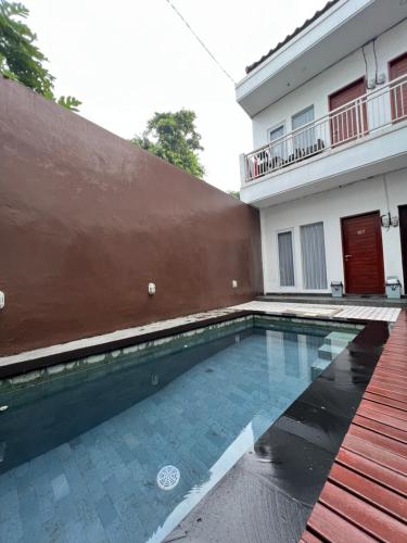 a swimming pool in front of a house at Coastal Room in Uluwatu