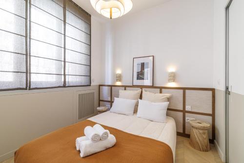 une chambre avec un grand lit avec des serviettes dessus dans l'établissement BERLIOZ - Splendid apartment in Nice city center, à Nice