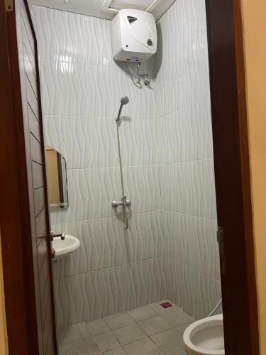 a bathroom with a shower and a toilet at Coastal Room in Uluwatu