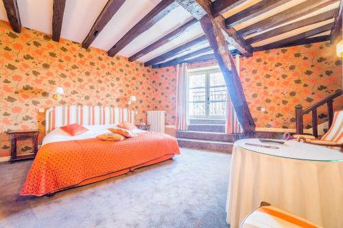 a bedroom with a bed and a table in it at Château de Castel Novel Boutique Hôtel in Varetz