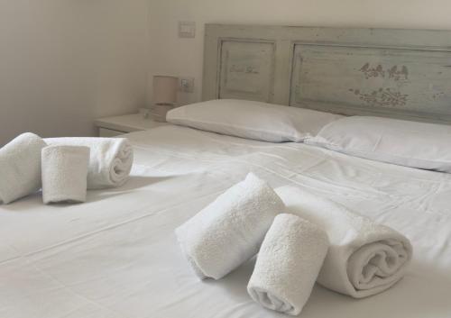 a white bed with towels on top of it at Casa Brezza Marina - Appartamento Brezza in Torre Lapillo