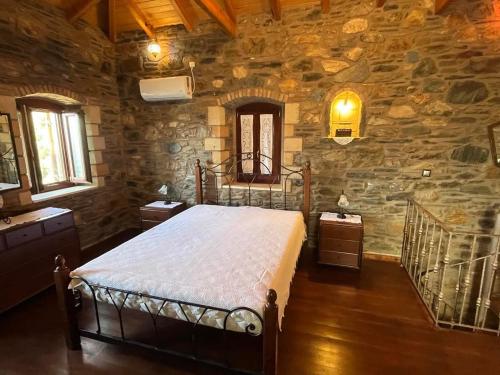 a bedroom with a bed and a stone wall at Paradisi Village in Neapolis