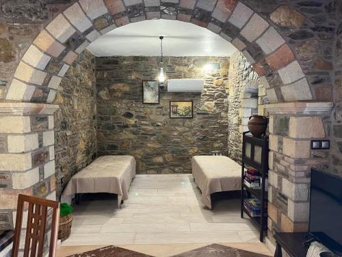 a room with two beds and a stone wall at Paradisi Village in Neapolis