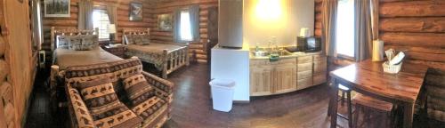 una sala de estar de una cabaña de madera con cocina en Authentic Log Cabin with a Deck in Chugach National Forest, Alaska, en Cooper Landing