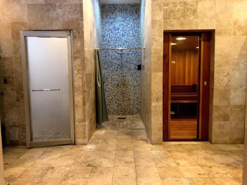 a hallway with two doors and a walk in shower at Departamento Mayan Lakes T9 - Albercas, club de playa, tenis, pádel y más in Acapulco