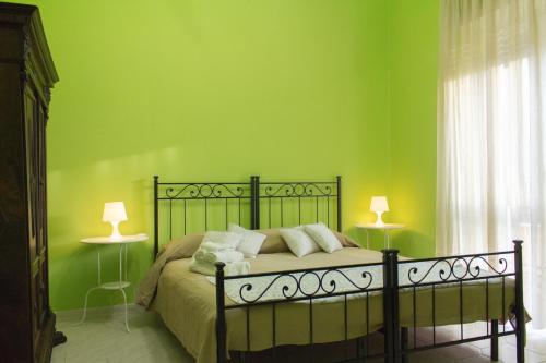 um quarto com uma cama com paredes verdes e 2 candeeiros em Gli Alloggi Di Papà em Roma