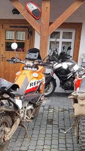 an orange motorcycle parked in front of a house at MOTOMYCZKI-motel in Myczkowce