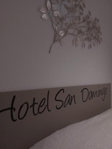 a bedroom with a sign that reads hotel san dunning at Hotel San Domingo in Lido di Camaiore