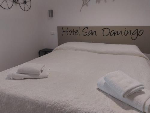 a white bed with two towels on top of it at Hotel San Domingo in Lido di Camaiore