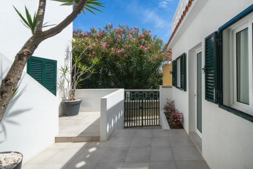 a white house with a gate and plants at Barlavento by An Island Apart in Porto Santo