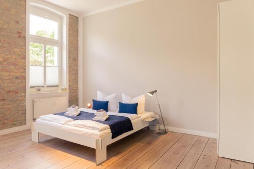 a bedroom with a bed with blue pillows and a window at OSTKÜSTE - Villa Albatros Design Apartments in Ahlbeck