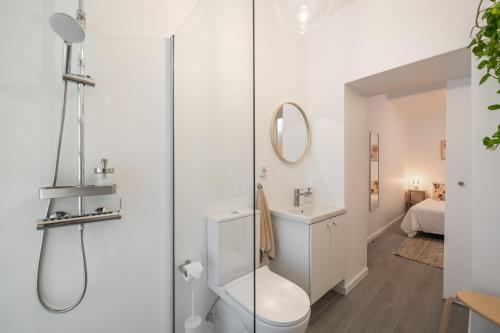 a bathroom with a shower and a toilet and a sink at Barlavento by An Island Apart in Porto Santo
