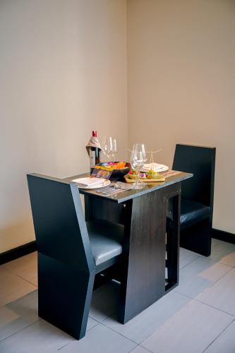 a table with chairs and wine glasses on it at Golden Tulip Mandison Suites in Bangkok