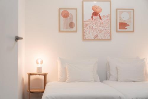 a bedroom with two beds and two pictures on the wall at Barlavento by An Island Apart in Porto Santo