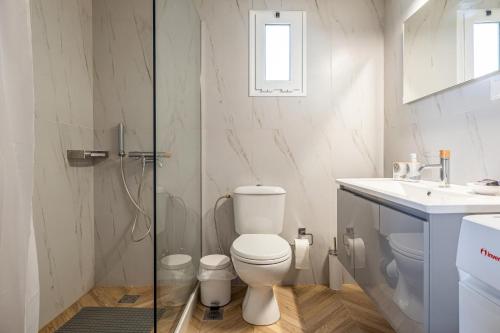 a white bathroom with a toilet and a sink at Elea Home in Goúrnes