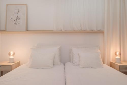 a bedroom with a white bed with white pillows at Barlavento by An Island Apart in Porto Santo