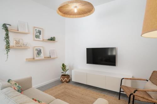 a living room with a tv on a white wall at Barlavento by An Island Apart in Porto Santo