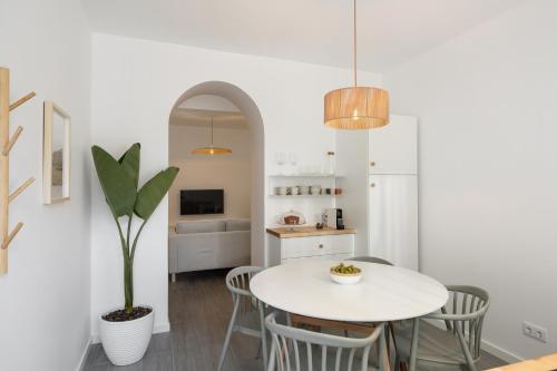 a kitchen and dining room with a white table and chairs at Barlavento by An Island Apart in Porto Santo
