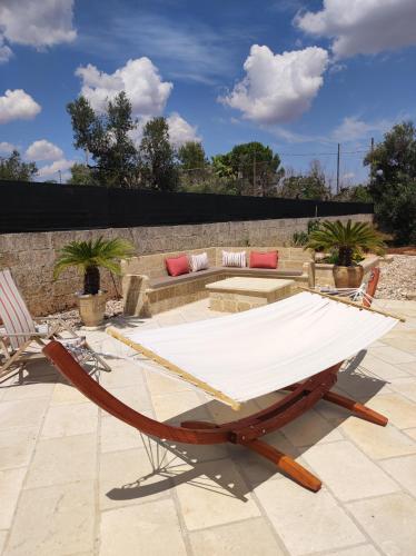 a hammock on a patio with a table and chairs at Contrada Macchia B&B in Tricase