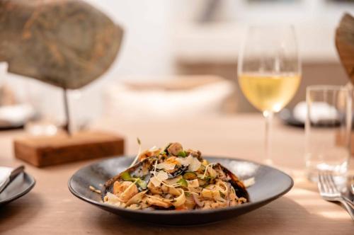 a plate of food on a table with a glass of wine at Kapama Karula in Kapama Private Game Reserve
