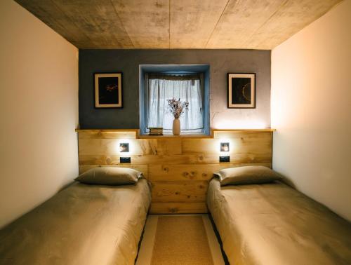 two beds in a room with a window at Locanda del Viandante by Heima in Faido