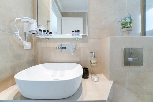 a bathroom with a white sink and a mirror at INROY SEA VIEW APARTMENTS in Skala Potamias