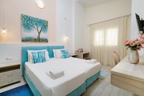 a bedroom with a large bed with a blue headboard at INROY SEA VIEW APARTMENTS in Skala Potamias