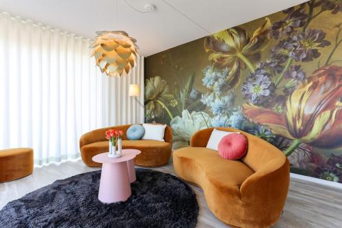 sala de estar con 2 sillas y un mural de flores en Uithaven 10B Kamperland, with harbour views, en Kamperland