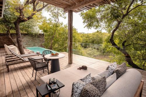 a patio with a couch and a table and a pool at Kapama Karula in Kapama Private Game Reserve