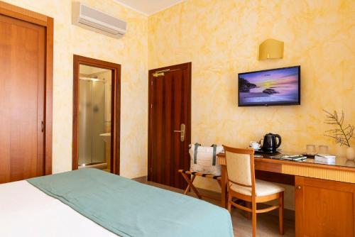 a hotel room with a bed and a desk and a television at Hotel & Residence Venezia 2000 in Venice-Lido