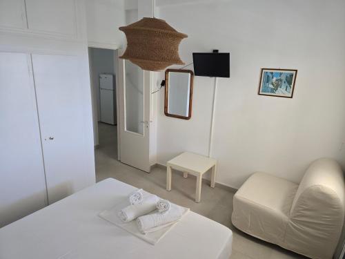 a white living room with a couch and a mirror at Oasis in Kamarai
