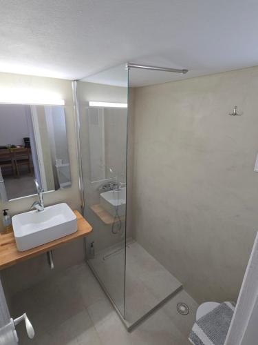 a bathroom with a glass shower with a sink at Oasis in Kamarai