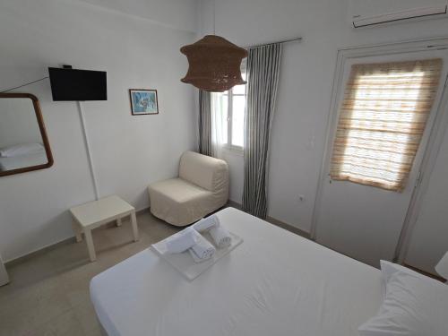 a white room with a bed and a chair at Oasis in Kamarai