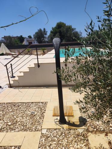a black pole in a yard with a pool at Contrada Macchia B&B in Tricase