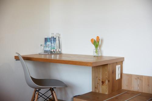 a wooden desk with a chair and a vase of flowers at Hotel Luitpold am See in Prien am Chiemsee
