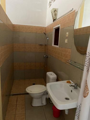 a bathroom with a toilet and a sink at Studio Poivre - Séjour tropical à Nosy Be in Madirokely