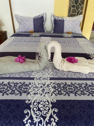 a bed with two swans made out of towels at Studio Poivre - Séjour tropical à Nosy Be in Madirokely