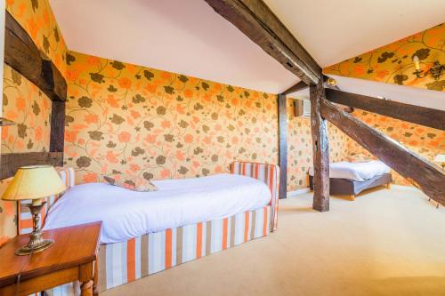 a bedroom with two beds and a desk with a lamp at Château de Castel Novel Boutique Hôtel in Varetz