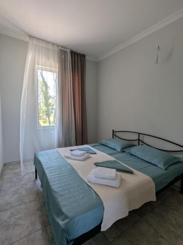 a bedroom with a large bed with towels on it at Nino apartments in Ureki