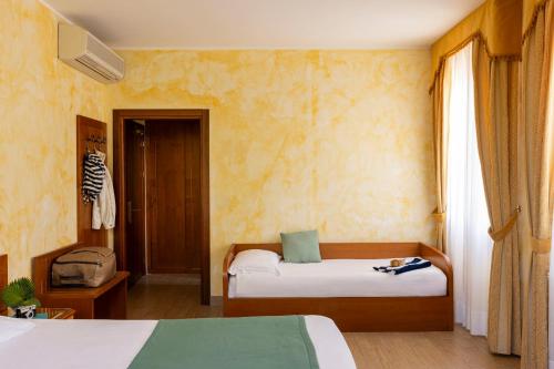 a bedroom with two beds and a window at Hotel & Residence Venezia 2000 in Venice-Lido