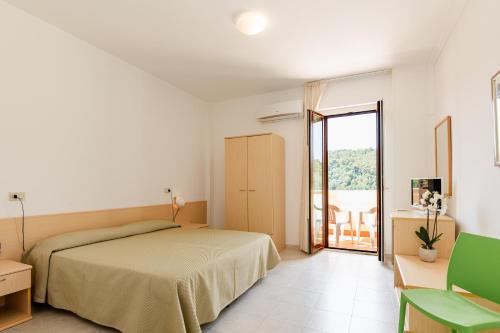 a bedroom with a bed and a sliding glass door at Hotel Sfinalicchio in Vieste