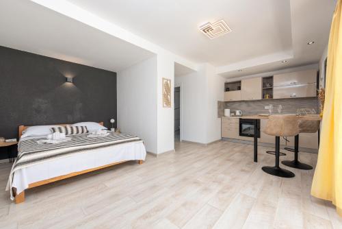 a bedroom with a bed and a desk and a kitchen at Unique Villa V with large pool in Benkovac