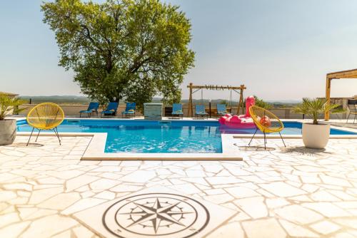 a swimming pool with two chairs and a playground at Unique Villa V with large pool in Benkovac