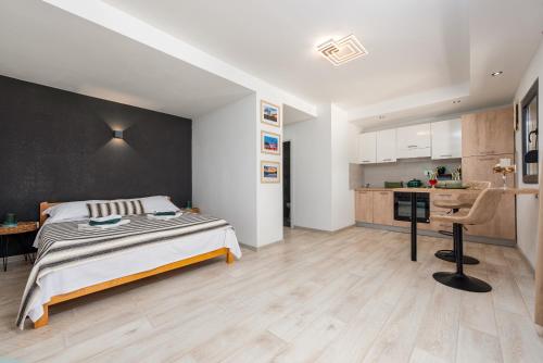 a bedroom with a bed and a desk and a kitchen at Unique Villa V with large pool in Benkovac
