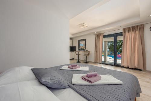 a bedroom with a large bed with two towels on it at Unique Villa V with large pool in Benkovac